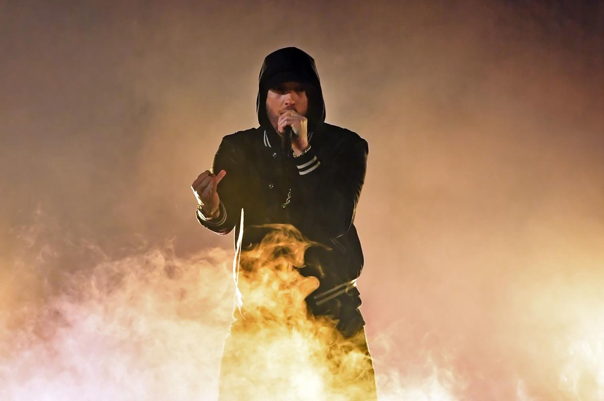 Eminem performing in front of a fire. 