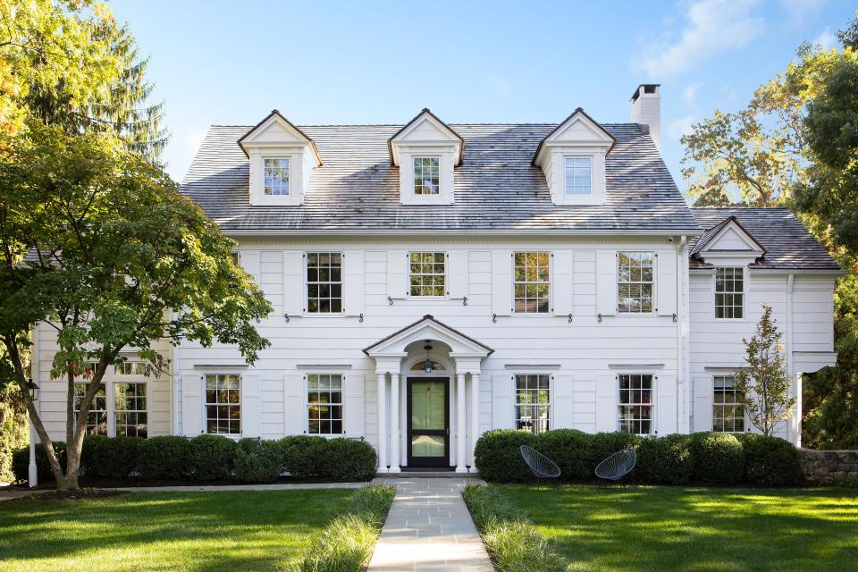 This updated home by Hiland Turner Architects maintains a sleek look thanks to its white shutters. The streamlined landscaping was handled by Leaf and Line.