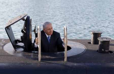 FILE PHOTO: Israeli Prime Minister Benjamin Netanyahu climbs out after a visit inside the Rahav, the fifth submarine in the Israeli Navy's fleet, after it arrived in Haifa port