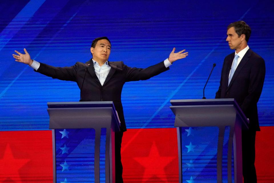 Former Texas Rep. Beto O'Rourke, right, listens to Andrew Yang, left, Thursday, Sept. 12, 2019, during a Democratic presidential primary debate hosted by ABC at Texas Southern University in Houston.