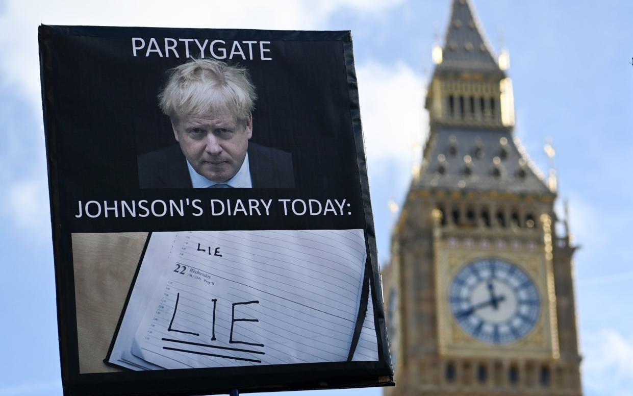 A protester demonstrates against former Prime Minister Boris Johnson outside the Houses of Parliament - Andy Rain/EPA/Shutterstock