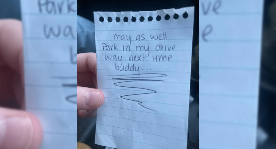 The driver holds up the note which was left on their car which reads, 'May as well park in my driveway next time buddy...'. 