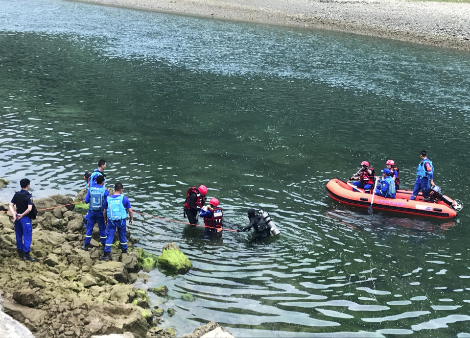 In this photo released by China's Xinhua News Agency, rescuers search a river after a boat capsized near Banrao village in southwestern China's Guizhou province, Friday, May 24, 2019. Chinese state media reported that a number of people died and others are missing after a boat capsized in southwestern China on Thursday evening. (Shi Qiangui/Xinhua via AP)