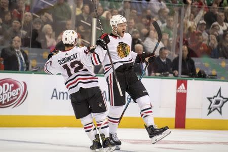 FILE PHOTO: Dec 2, 2017; Dallas, TX, USA; Chicago Blackhawks right wing Alex DeBrincat (12) and defenseman Cody Franson (11) celebrates a goal by Franson against the Dallas Stars during the first period at the American Airlines Center. Jerome Miron-USA TODAY Sports