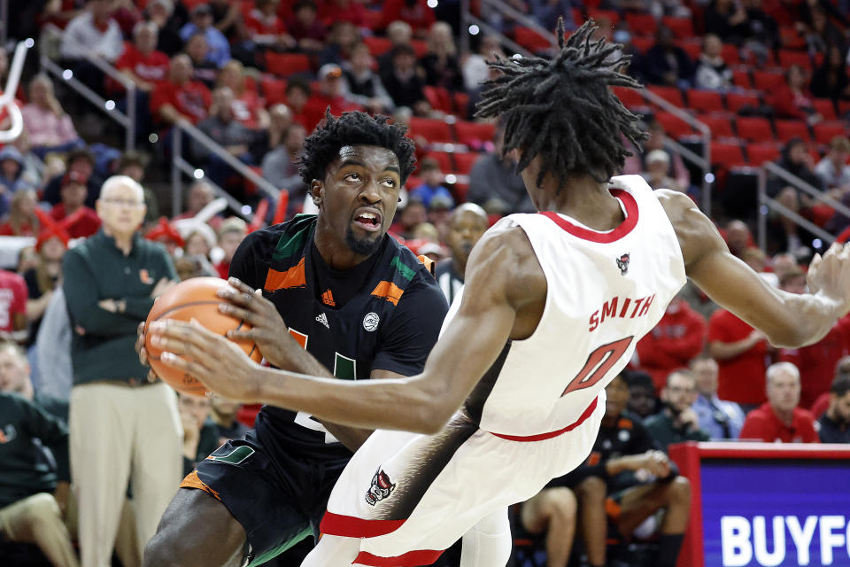 Miami's Bensley Joseph (4) drives the ball into North Carolina State's Terquavion Smith (0) during the second half of an NCAA college basketball game in Raleigh, N.C., Saturday, Jan. 14, 2023. (AP Photo/Karl B DeBlaker)