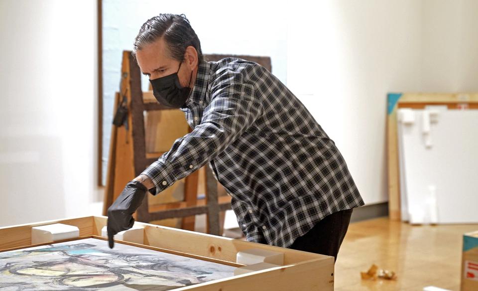 Albert Chamillard, University of Arizona exhibit specialist, examines "Woman-Ochre" after uncrating the oil painting on Sept. 14, 2022.