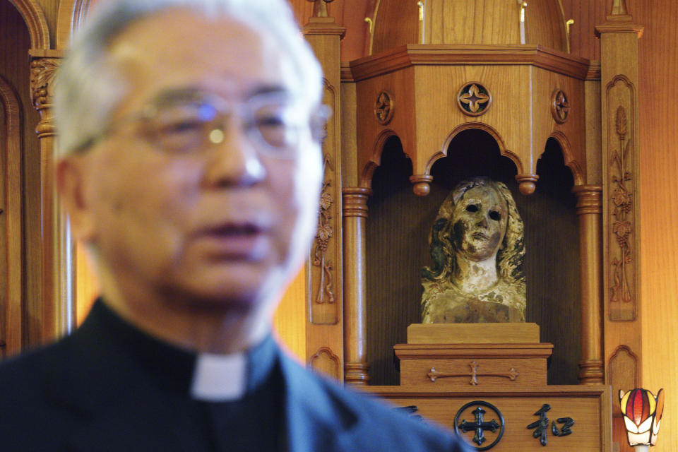 In this Nov. 16, 2019, photo, Japanese Archbishop Mitsuaki Takami, who heads Nagasaki's Catholic community of 60,000, speaks in front of a statue of the Virgin Mary that was damaged in the A-bomb attack at the Urakami Cathedral in Nagasaki, southern Japan. Pope Francis will start his first official visit to Japan in Nagasaki, ground zero for the Christian experience in a nation where the Catholic leader once dreamed of living as a missionary. (AP Photo/Eugene Hoshiko)