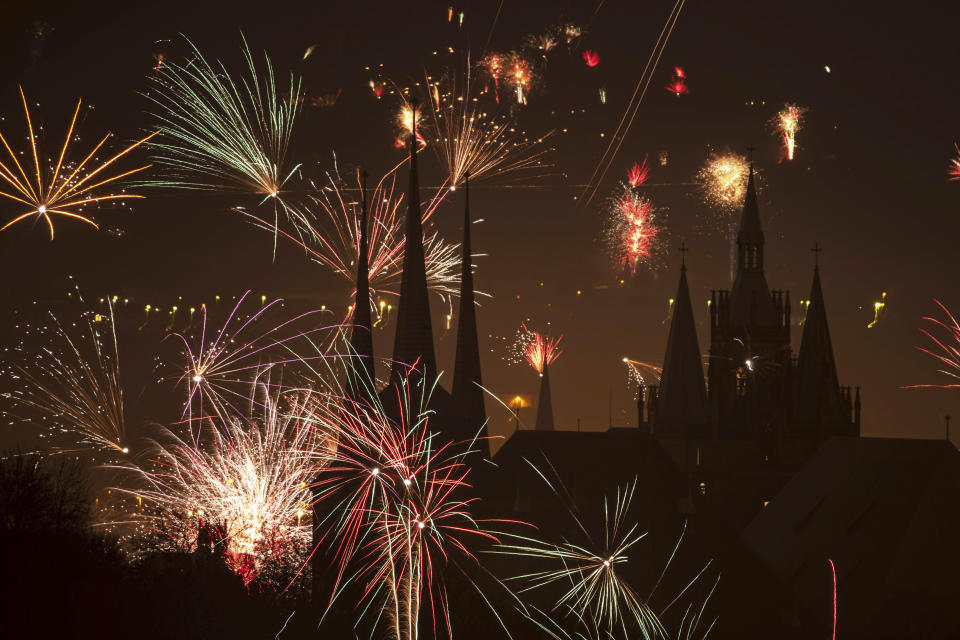 Fireworks light the sky above the St. Severi's Church, left, and the Mariendom (Cathedral of Mary), right, during New Year's celebrations in Erfurt, central Germany, Wednesday, Jan. 1, 2020. (AP Photo/Jens Meyer)