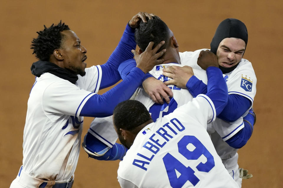 Kansas City Royals' Salvador Perez, top center, celebrates with teammates after hitting a single to drive in the winning run during the ninth inning of the team's baseball game against the Tampa Bay Rays on Wednesday, April 21, 2021, in Kansas City, Mo. The Royals won 9-8. (AP Photo/Charlie Riedel)