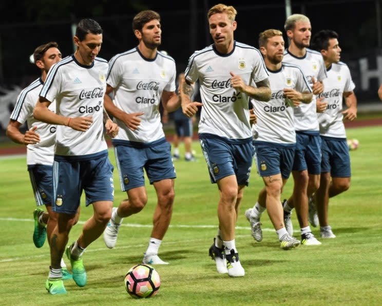 Argentina’s Angel Fabian Dimaria (L), Federico Fazio (2nd L) and Lucas Biglia 3rd R) and teammates warm up during a training session at Bishan stadium in Singapore on June 11, 2017. Argentina will play against Singapore in an International friendly football match at the National Stadium on June 13. / AFP PHOTO / ROSLAN RAHMAN