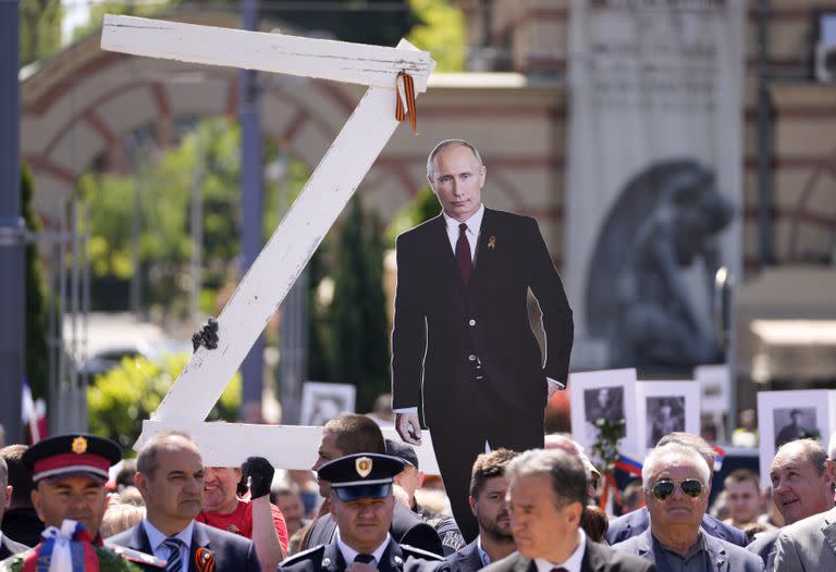 Personas sostienen una imagen del presidente ruso Vladimir Putin y una letra Z, durante la ceremonia del Día de la Victoria en Belgrado, Serbia, el lunes 9 de mayo de 2022.