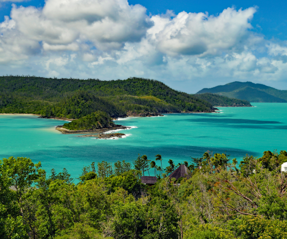 A photo of Hamilton Island featuring lush green trees and crystal clear waters