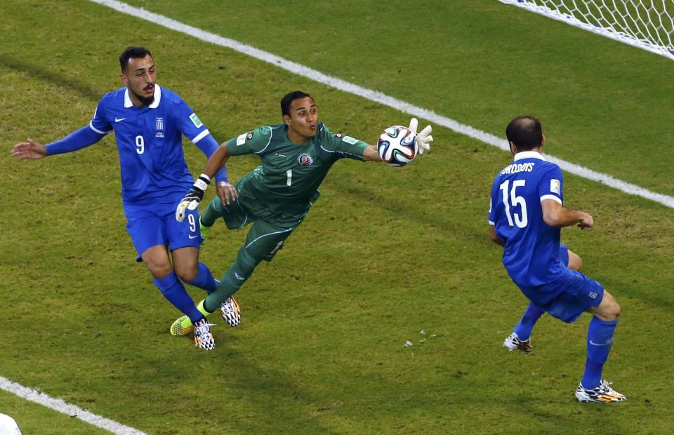 Costa Rica's goalkeeper Keilor Navas makes a save, as Greece's Konstantinos Mitroglou (9) and Vasilis Torosidis watch, during their 2014 World Cup round of 16 game at the Pernambuco arena in Recife June 29, 2014. REUTERS/Ruben Sprich