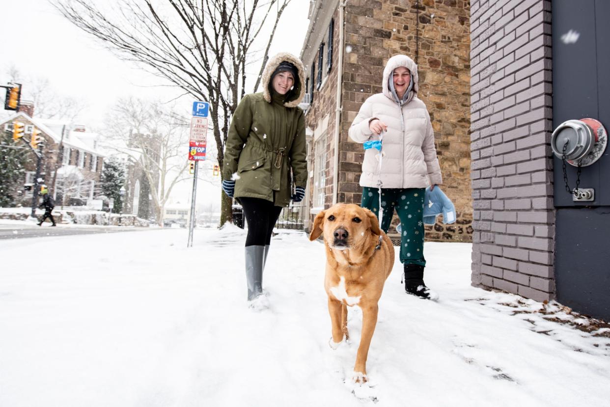 Kylea Loughery, left, and Caitlyn Courchain, of Doylestown Borough, walk their dog, Ivy, a labrador mix, in Doylestown Borough, during a winter storm that impacted the region on Friday, January 19, 2024.