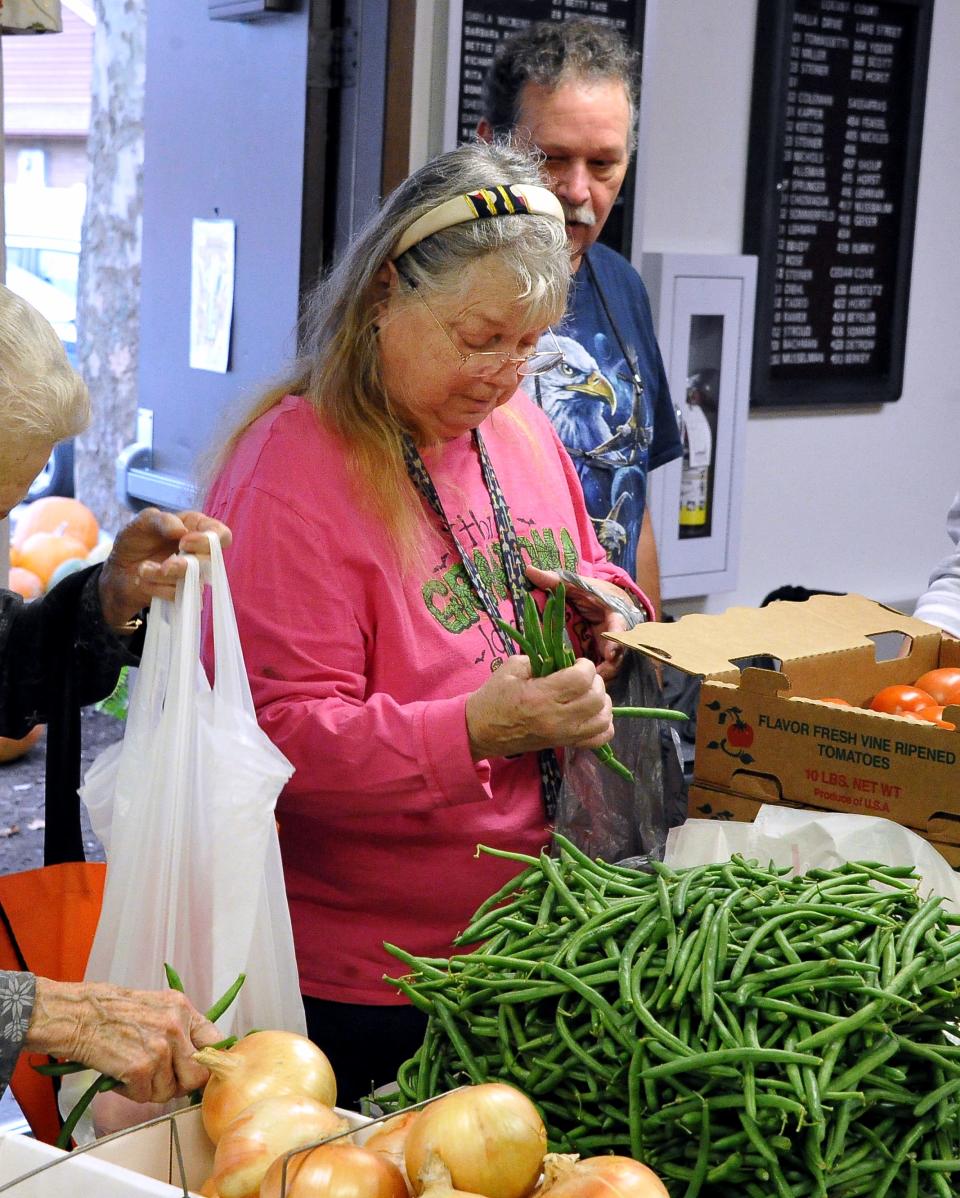 OrrVilla Evergreen Place resident Janet Berg grabs a handful of freshly picked green beans for a meal.