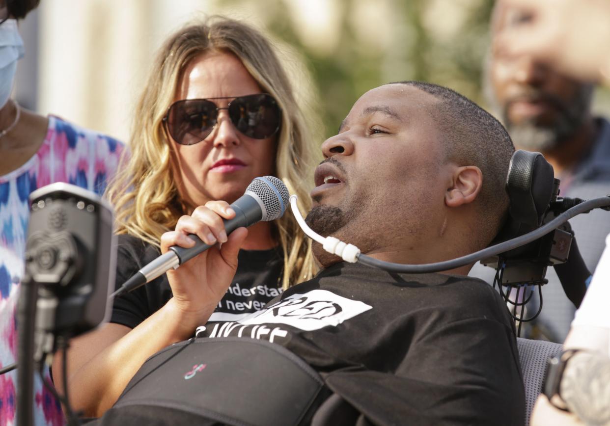 FILE - In this June 6, 2020 file photo, Jerime Mitchell speaks to the crowd as his wife Bracken holds the microphone during a protest against police brutality at Greene Square in Cedar Rapids, Iowa. An insurance company for the City of Cedar Rapids will pay $8 million to Mitchell, who was paralyzed after police officer Lucas Jones shot him during a 2016 traffic stop. 