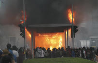 Protesters gather around a burning metro station during a rally in Jakarta, Indonesia, Thursday, Oct. 8, 2020. Thousands of enraged students and workers staged rallies across Indonesia on Thursday in opposition to a new law they say will cripple labor rights and harm the environment. (AP Photo/Achmad Ibrahim)