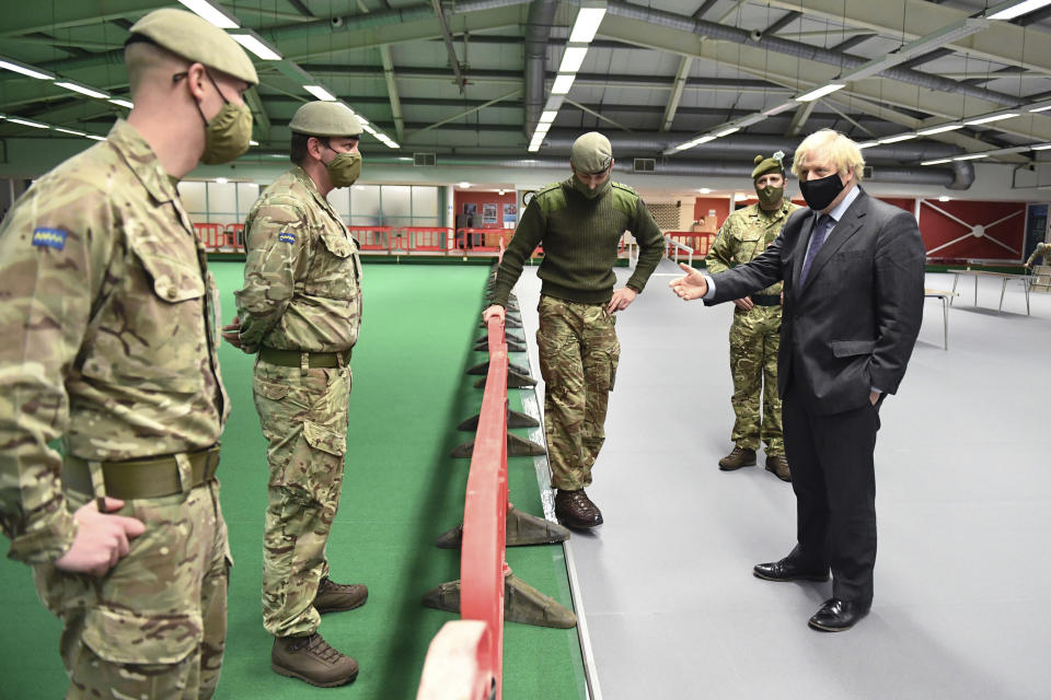 Britain's Prime Minister Boris Johnson meets troops setting up a vaccination centre in the Castlemilk district of Glasgow, on his one day visit to Scotland, Thursday, Jan. 28, 2021. Johnson is facing accusations that he is not abiding by lockdown rules as he makes a trip to Scotland on Thursday to laud the rapid rollout of coronavirus vaccines across the United Kingdom. (Jeff Mitchell/Pool Photo via AP)