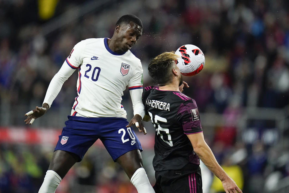 United States' Tim Weah, left, goes up for the ball against Mexico's Hector Herrera during the first half of a FIFA World Cup qualifying soccer match, Friday, Nov. 12, 2021, in Cincinnati. (AP Photo/Julio Cortez)