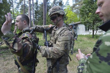 A serviceman of the U.S. Army's 173rd Airborne Brigade Combat Team (C) trains Ukrainian soldiers during a joint military exercise called "Fearless Guardian 2015" at the military training area in Yavoriv, outside Lviv, Ukraine, May 12, 2015. REUTERS/Oleksandr Klymenko