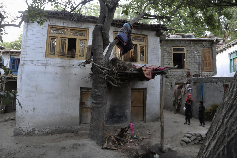 A sister and children of Mohammed Hassan, a Pakistani porter who died on July 27 during a summit of K2, stand outside their home in Tasar, a village in the Shigar district in the Gilgit-Baltistan region of northern Pakistan, Saturday, Aug. 12, 2023. An investigation has been launched into the death of a Hassan near the peak of the world's most treacherous mountain, a Pakistani mountaineer said Saturday, following allegations that dozens of climbers eager to reach the summit had walked past the man after he was gravely injured in a fall. (AP Photo/M.H. Balti)