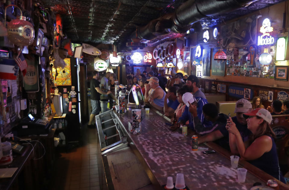 Locals have a drink as they relax at the Barbary Coast bar in downtown Wilmington, N.C., as Florence threatens the coast Thursday, Sept. 13, 2018. (AP Photo/Chuck Burton)