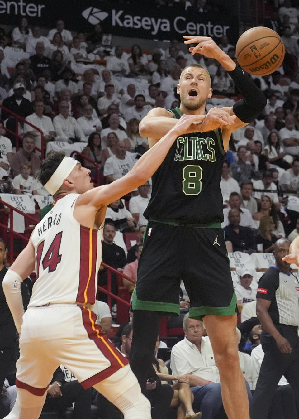 Miami Heat guard Tyler Herro (14) fouls Boston Celtics center Kristaps Porzingis (8) during the first half of Game 4 of an NBA basketball first-round playoff series, Monday, April 29, 2024, in Miami. (AP Photo/Marta Lavandier)