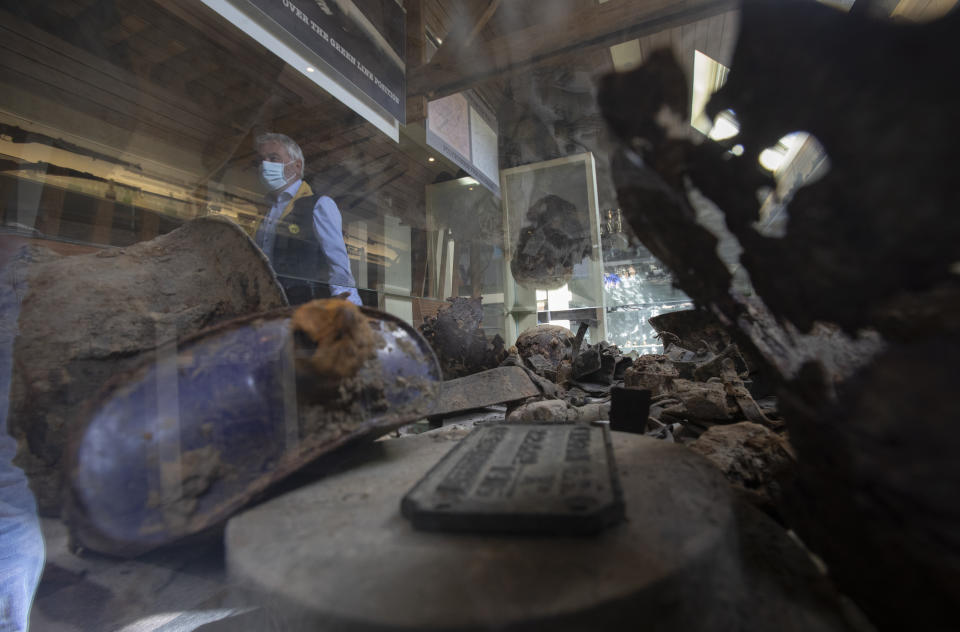 Belgian amateur archeologist Johan Vandewalle stands behind a glass case containing World War I items found in the vicinity of Polygon wood in Zonnebeke, Belgium, Thursday, April 22, 2021. On another Anzac Day turned lonesome by the global pandemic, solitary actions show all the more how the sacrifices of Australia and New Zealand during World War I are far from forgotten. While global attention will turn at dawn on Sunday to the beaches of Turkey’s Gallipoli where the two emerging countries crafted a sense of nationhood from the horrors of war in April 1915, all along the front line in Europe, small ceremonies will show gratitude over a century after the war ended. (AP Photo/Virginia Mayo)