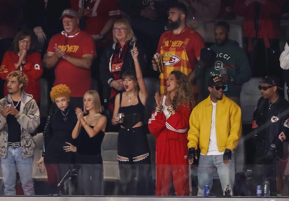 Taylor Swift (de negro, levantando su brazo izquierdo) en uno de los palcos del Allegiant Stadium presenciando la edición LVIII del Super Bowl.