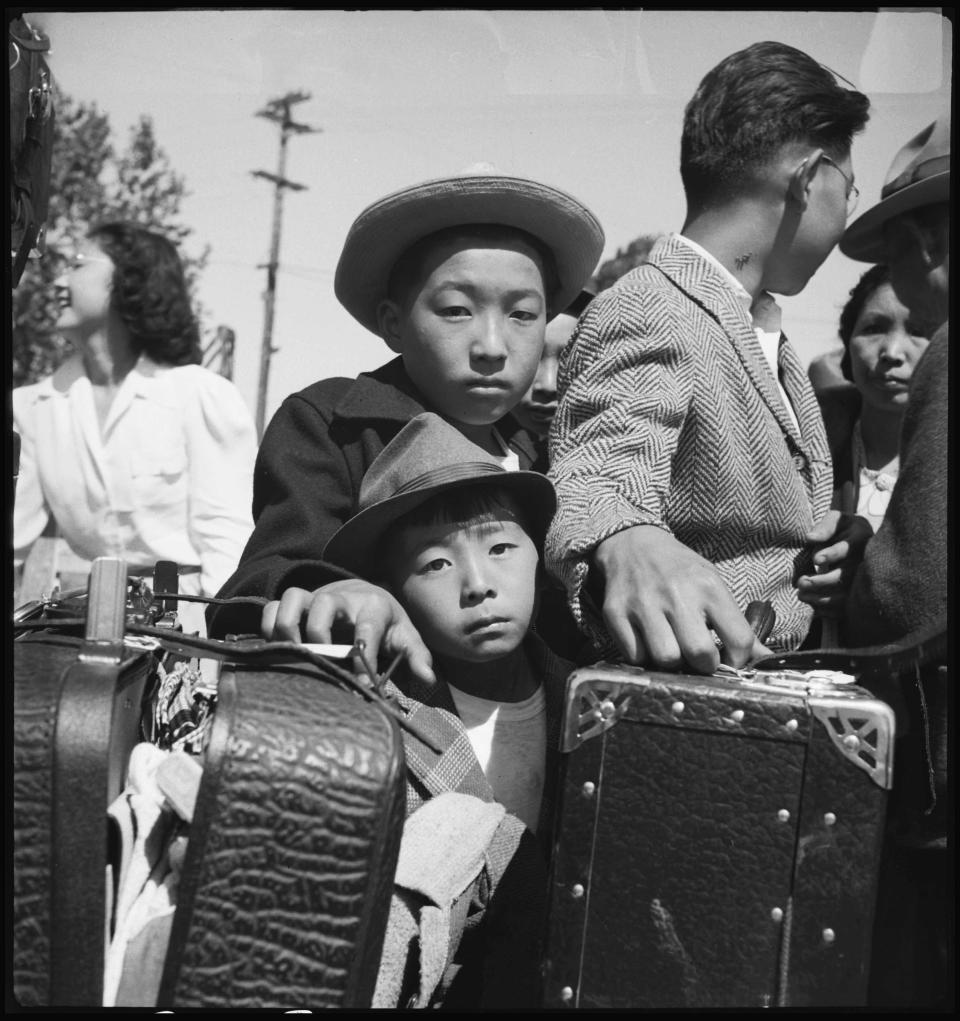 Dorothea Lange's "Lined Up for Evacuation," taken in California in May 1942 during the U.S. roundup and incarceration of Japanese Americans in World War II.