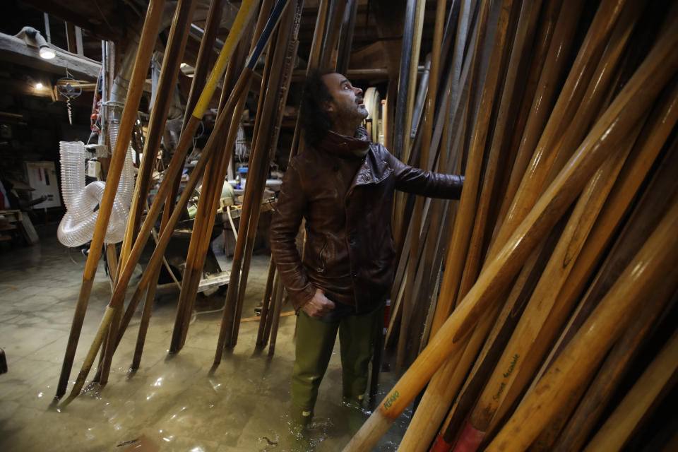 In this photo taken on Sunday, Nov. 17, 2019, Paolo Brandolisio stands in his oars flooded laboratory, in Venice, Italy. Venetians are fed up with what they see as an inadequate to the city's mounting problems: record-breaking flooding, damaging cruise ship traffic and over-tourism. They feel largely left to their own devices, and with ever fewer Venetians living in the historic part of the city to defend its interests and keep it from becoming a theme park or museum.(AP Photo/Luca Bruno)