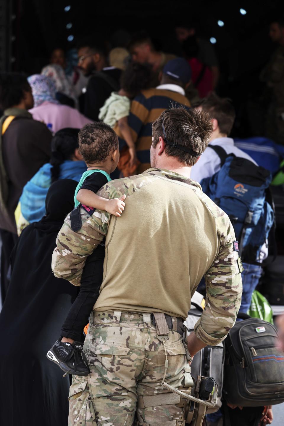 In this handout image provided by the UK Ministry of Defence, on Thursday, April 27, 2023, British Nationals board an RAF aircraft for evacuation of civilians to Larnaca International Airport in Cyprus, at Wadi Seidna military airport, 22 kilometres (14 mi) north of Khartoum, Sudan. The UK government assisted by the British Military has evacuated British Citizens from Sudan. RAF flights are continuing between Wadi Seidna airport in Sudan to Larnaca International Airport, following three evacuation flights that took place late overnight between Tuesday 25 April and Wednesday 26 April. (PO Phot Aaron Hoare/UK Ministry of Defence via AP)