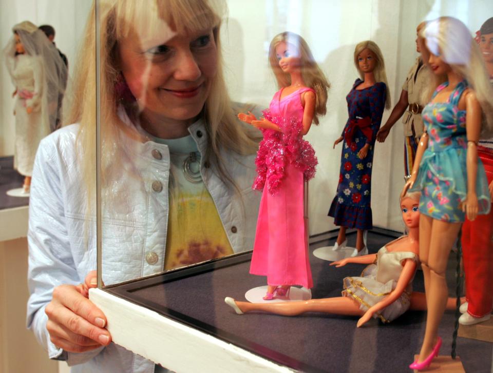 Tina Dorfmann looks at parts of her "Barbie" doll exhibition in Cologne, western Germany, Friday, Aug. 31, 2007. At the Cologne city museum visitors may have a look to around 320 Barbie dolls during the exhibition fom Sept.1 to Oct. 28, 2007. (AP Photo/Roberto Pfeil)