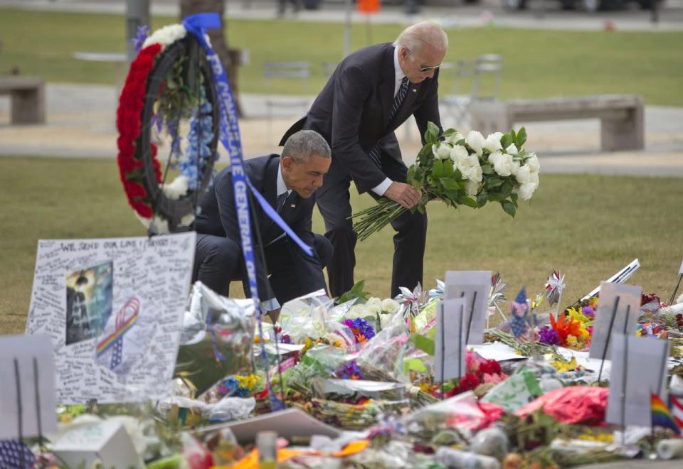 President Barack Obama and Vice President Joe Biden place flowers down during their visit to a memorial to the victims of the Pulse nightclub shooting, Thursday, June 16, 2016 in Orlando, Fla. (AP Photo/Pablo Martinez Monsivais)