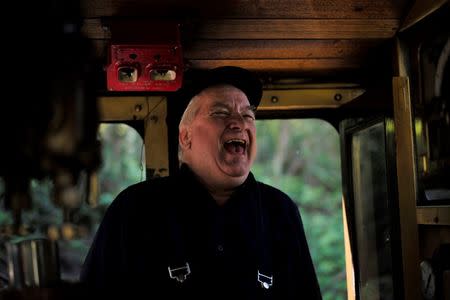 Puffing Billy steam engine driver Steve Holmes, 61, laughs as he jokes with fireman Barry Rogers on the footplate of a locomotive at Lakeside Station near Melbourne, October 20, 2014. REUTERS/Jason Reed