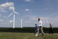 President Barack Obama walks with Jeff (L) and Richard (R) Heil on the Heil Family Farm, a wind farm, while in Haverhill, Iowa, August 14, 2012.