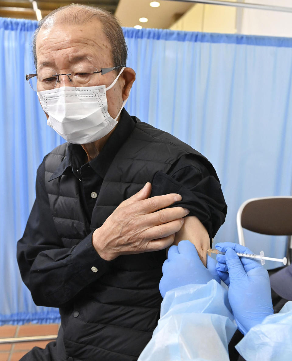 An elderly man receives his first dose of Pfizer's COVID-19 vaccine at Hachioji City Hall in Tokyo Monday, April 12, 2021. Japan started its vaccination drive with medical workers and expanded Monday to older residents, with the first shots being given in about 120 selected places around the country. (Kyodo News via AP)