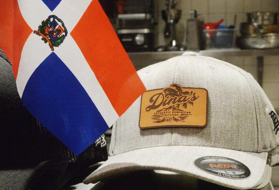 A Dominican Republic flag sits near a cap for sal at Dina's Authentic Dominican Kitchen.