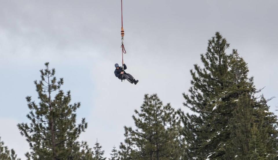 Pat Lansing, a lineman with Wasatch Electric, is lowered from a helicopter in Truckee earlier this month. The recent heavy snow in the Sierra caused power outages to many homes and transporting workers by helicopter is the easiest way to get them to remote places. Hector Amezcua/hamezcua@sacbee.com