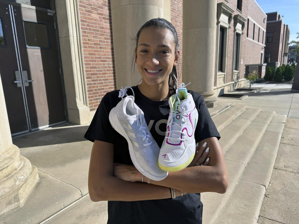 University of Nebraska volleyball player Harper Murray poses with her Avoli, right, and Adidas, left, volleyball shoes on the school campus in Lincoln, Neb., Sunday, Oct. 8, 2023. A volleyball shoe startup is bringing attention to colleges' multi-million-dollar contracts with athletic apparel companies and terms that prevent athletes from wearing other brands. Nebraska volleyball player Harper Murray is an ambassador for Avoli. (AP Photo/Eric Olson)