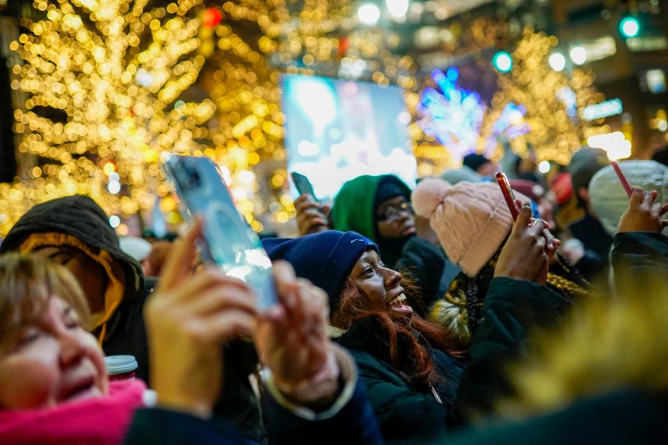 Angel Lindsey, center, of Detroit, takes a photo with others as the Salvation Army kettle is lit during the 19th annual Detroit Tree Lighting presented by the DTE Foundation on Friday, Nov. 18, 2022, at Campus Martius Park in downtown Detroit.