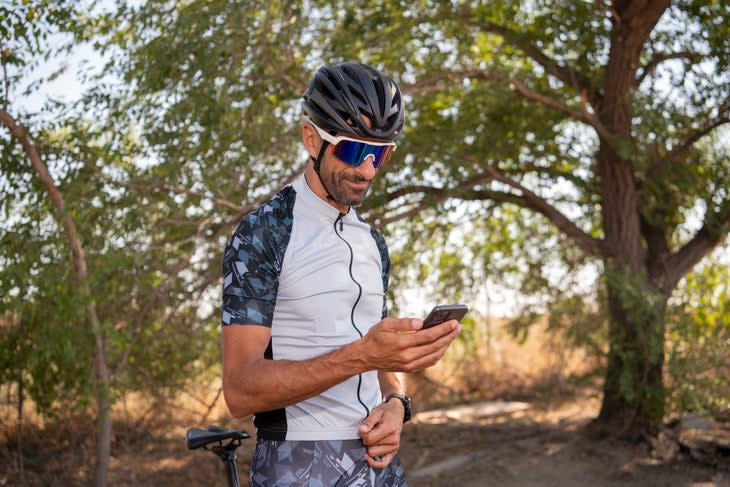 A cyclist checks how to repair his phone after a bike ride