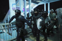 Riot police gather outside the Yuen Long MTR station during a protest in Hong Kong, Wednesday, Aug. 21, 2019. Hong Kong riot police faced off with protesters occupying a suburban train station Wednesday evening following a commemoration of a violent attack there by masked assailants on supporters of the anti-government movement. (AP Photo/Kin Cheung)