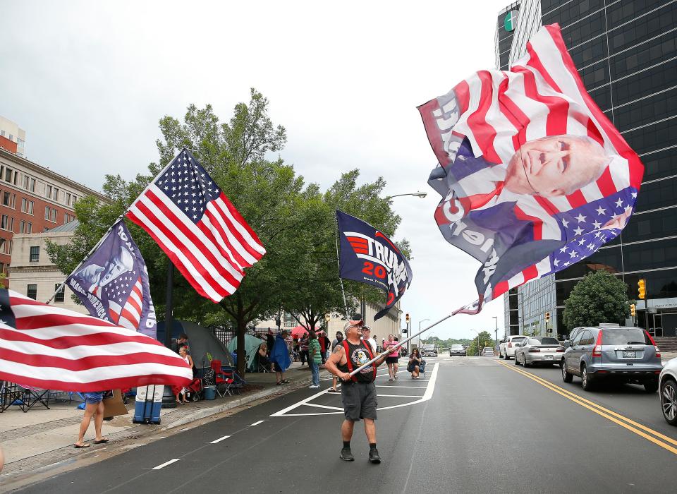 Randal Thom waves a Trump flag in downtown Tulsa ahead of President Donald Trump's Saturday campaign rally, Friday, June 19, 2020.