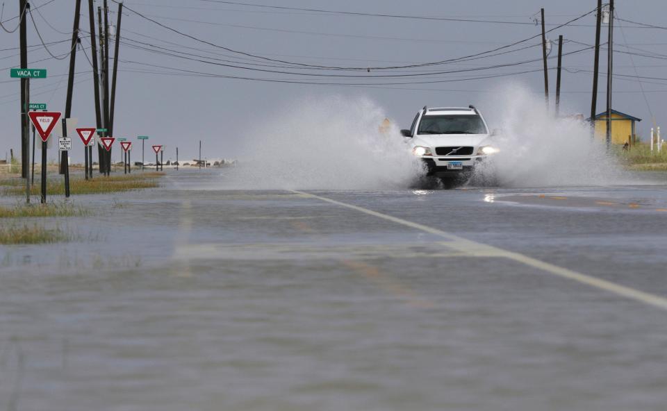 A car drives through a road as flood waters come in from Tropical Storm Gordon on Tuesday, Sept. 4, 2018 in Dauphin Island, Ala.