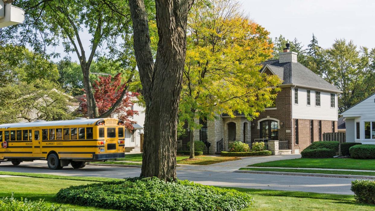 school bus driving through suburbs