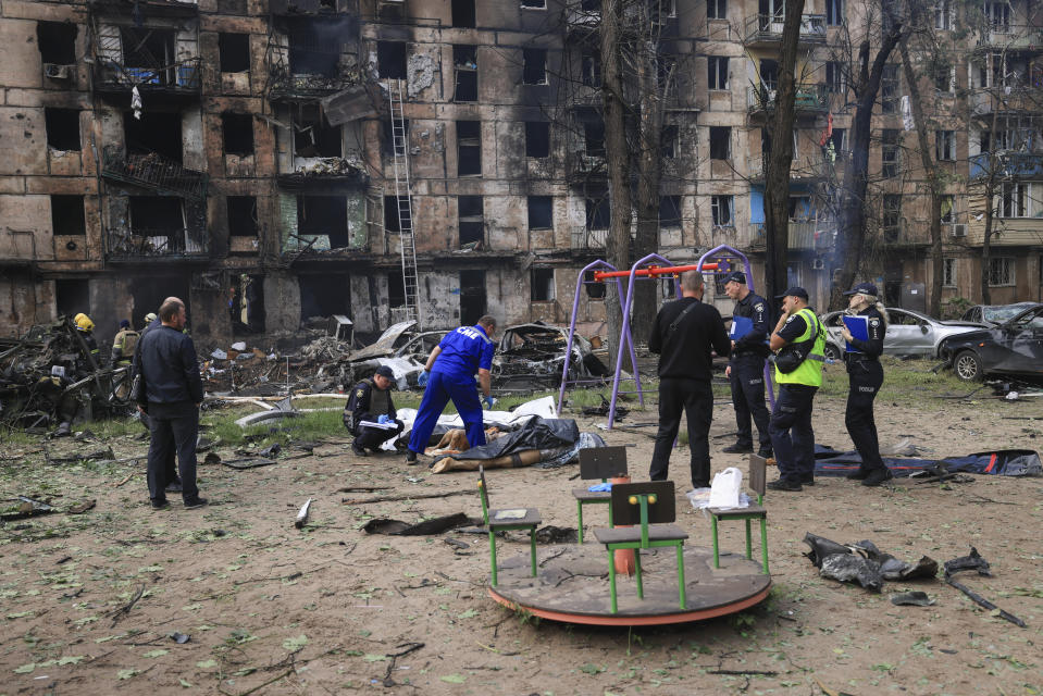 Police inspect a dead body at the scene of a damaged multi-storey apartment building caused by the latest rocket Russian attack in Kryvyi Rih, Ukraine, Tuesday, June 13, 2023. (AP Photo/Andriy Dubchak)