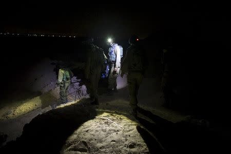 Israeli soldiers walk towards Israel's border fence with Southern Gaza before repairing a malfunction July 8, 2015. REUTERS/Ronen Zvulun