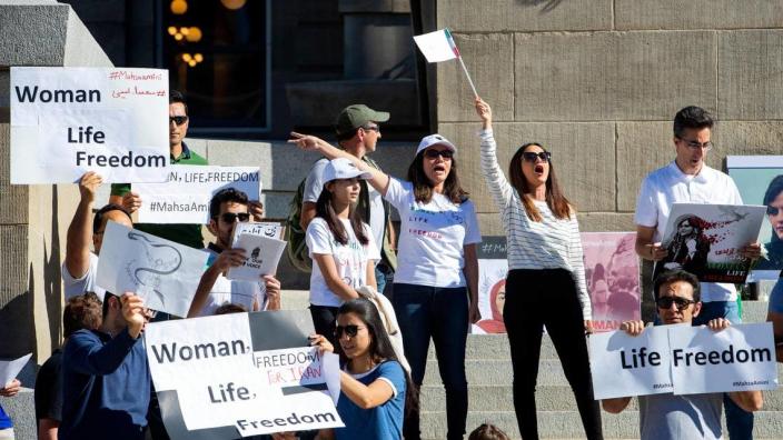 Asal Syes, center left, and Afagh Faramarzi, with an Iranian flag, lead a call at a rally at the Idaho Capitol against the treatment of women Iran. Women in Iran have been demonstrating against the government after the death of Mahsa Amini, a 22-year-old woman who was taken into custody for allegedly not dressing modestly.