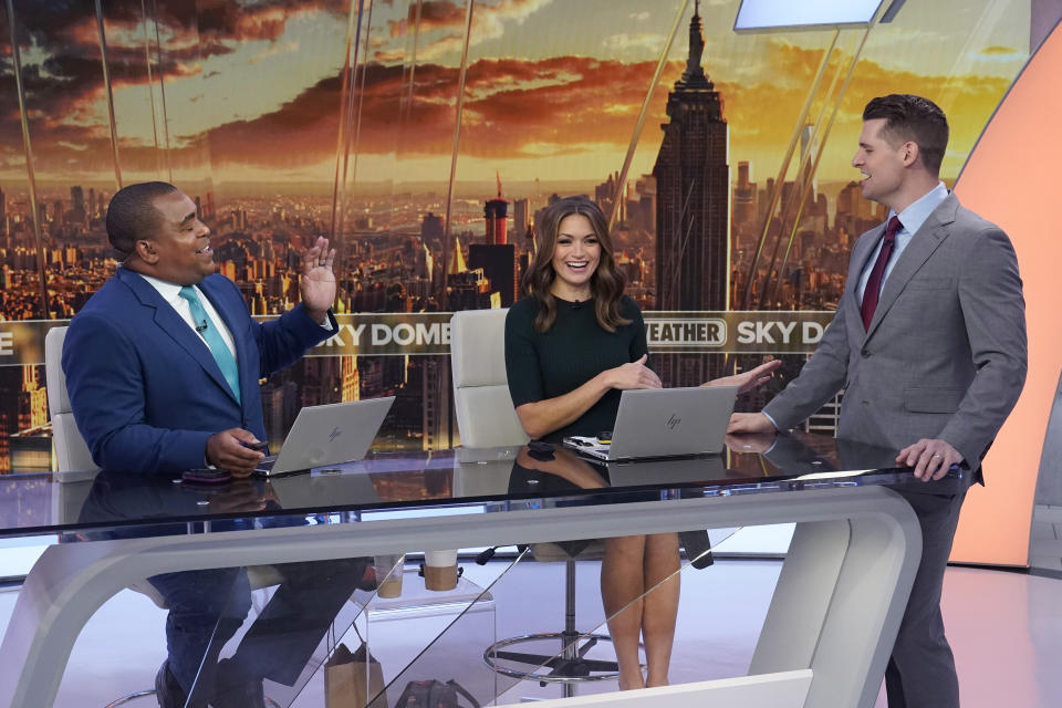 Co-anchors Jason Frazer, from left, Britta Merwin, and Stephen Morgan rehearse on the Fox Weather set at News Corporation headquarters in New York, Wednesday, Oct. 20, 2021. Fox Weather, a free streaming service and app, will launch on Monday. (AP Photo/Richard Drew)